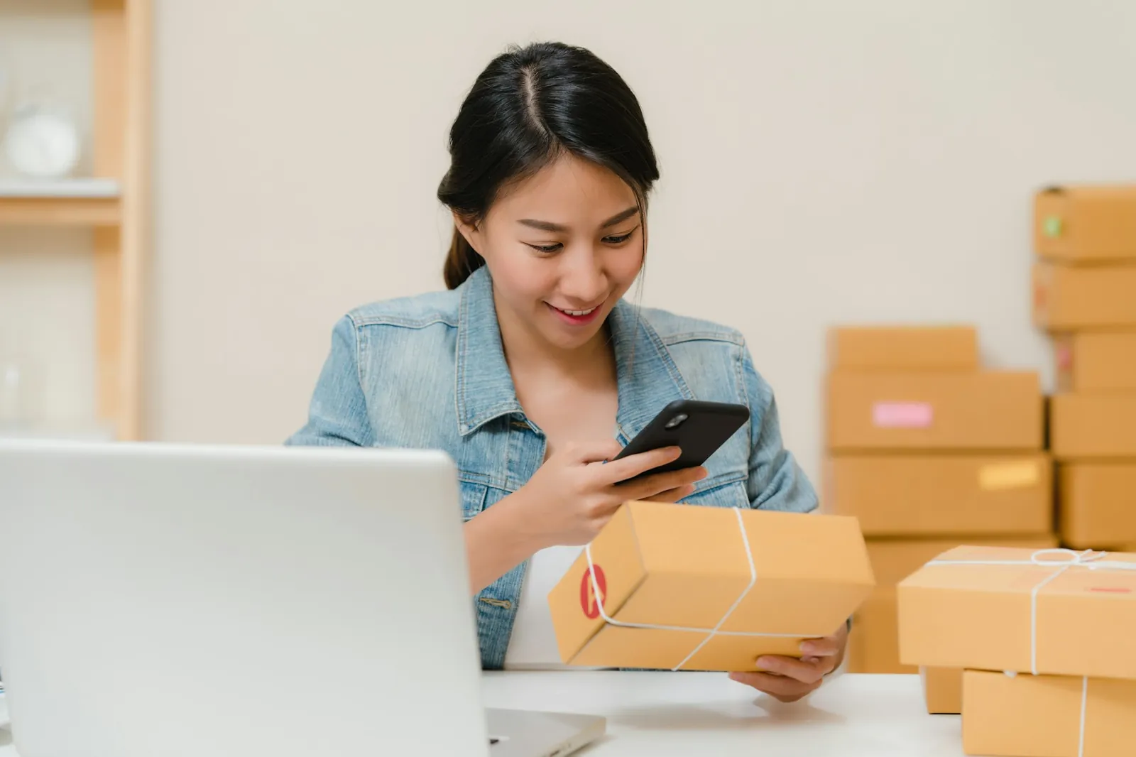 Two people packing online orders at a long workbench in a bright fulfilment studio