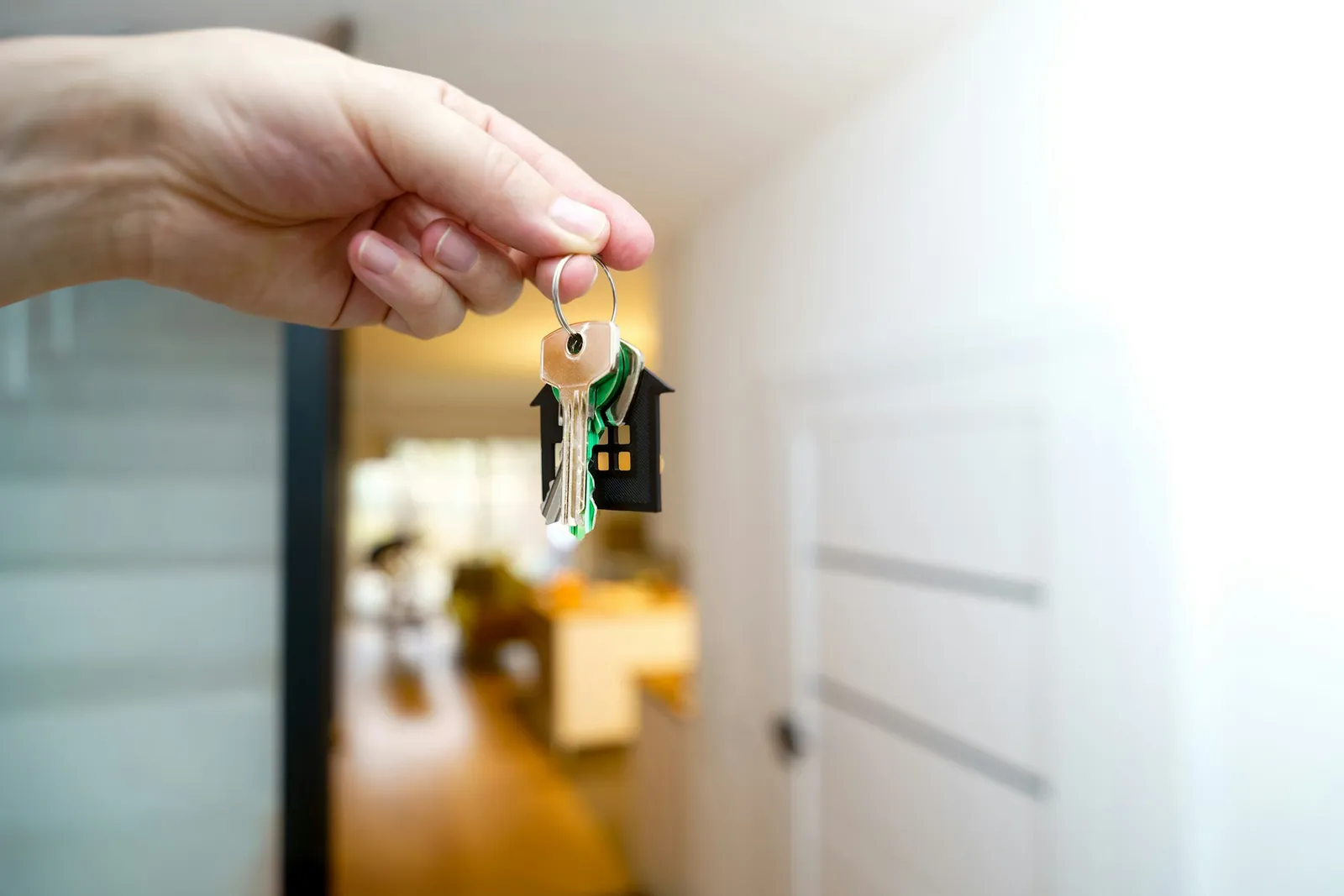 Property advisor showing a couple around a bright apartment while checking a message on her phone